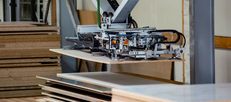 Automatisierter Prozess von einem Handlingroboter der Holzplatten ansaugt 