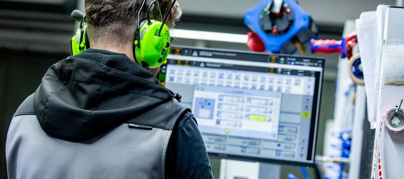 Mitarbeiter konrtolliert an der Maschine die Werte für eine Fronten- & Möbelteillösung